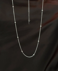 Detail of silver snake chain necklace with polished beads and adjustable extender