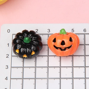 Close-up of small resin Halloween pumpkins with size scale on a pink background