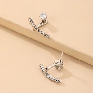 Detailed close-up of J-shaped silver studs with sparkling cubic zirconia pavé setting