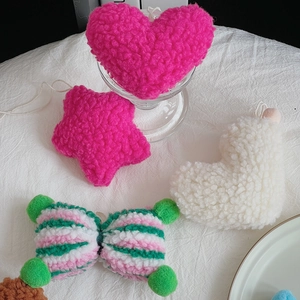Close-up of soft lamb wool plush charms in heart and star shapes for DIY Christmas decor