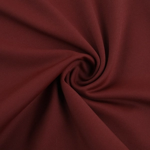 Detailed macro view of burgundy knit fabric texture with soft drape and spiral pattern
