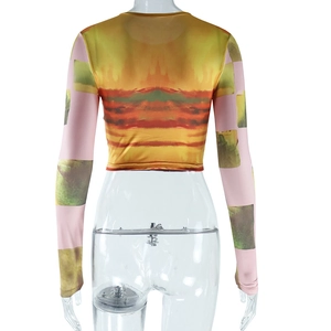 Dettaglio del crop top tie-dye con stampa nuvola arancione e maniche a quadri verdi