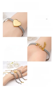 Dettaglio del ciondolo a cuore in oro 18K su bracciale regolabile in maglia d'acciaio