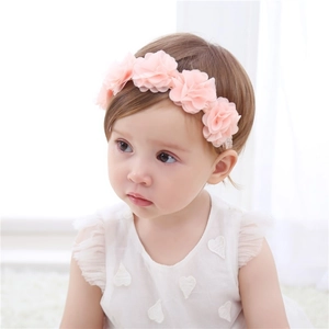 Close-up of pink chiffon floral elastic headband worn by a baby girl for party wear.