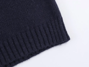 Macro shot of dark blue knitted fabric showing detailed rib-knit texture and soft wool fibers