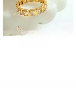 Detailed macro view of gold-plated eternity ring with baguette-cut rectangular stones