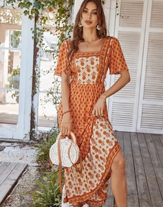 Floral print maxi dress with square neck and short sleeves on a bright wooden deck