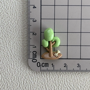 Vue détaillée d'un petit arbre en résine de 2 cm avec os blanc sur papier quadrillé