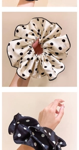 Detail of elegant polka dot silk scrunchies in beige and black with satin finish