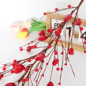 Close-up of red berry heart branch with Feb 14 calendar for Valentine's Day decor