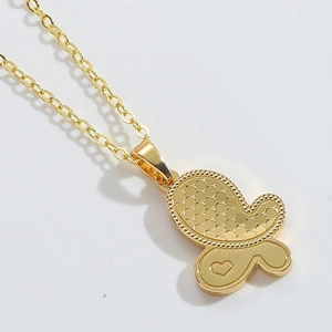 Macro shot of double-layered gold butterfly pendant with heart engraving on fine metal chain