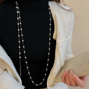 Gros plan d'un collier de perles multicouche élégant sur un mannequin en veste