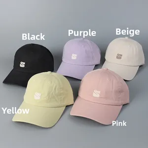 Detail of embroidered cotton baseball caps in black, purple, beige, yellow, and pink colors