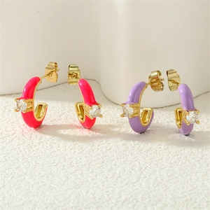 Detailed close-up of C-shaped enamel earrings with sparkling cubic zirconia inlay