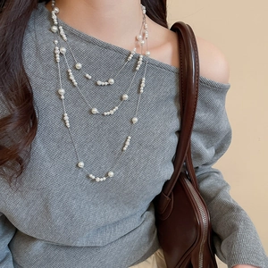 Detailed view of elegant multi-layer pearl necklace with sparkling rhinestones on model