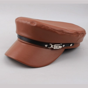 Detail of vintage brown PU leather newsboy hat with black strap and silver metal buckle