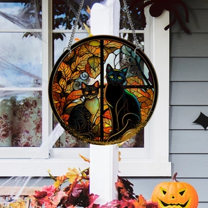 Close-up of Halloween suncatcher with black cats and autumn leaves decoration