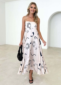 Detail of bohemian floral maxi dress featuring thin straps and abstract sun prints
