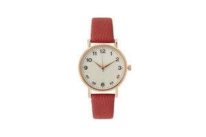 Close-up of rose gold watch case with red leather strap and minimalist numeric dial