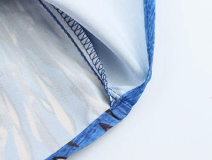 Close-up of blue floral fabric stitching and hem finish on a vacation style two-piece set