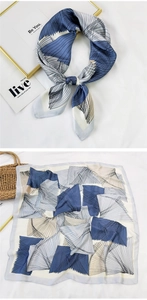Detail of a square silk scarf with blue and white geometric patterns on a white cloth