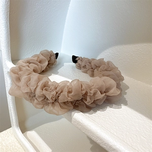 Close-up of pleated organza headband in champagne color with elegant mesh texture details