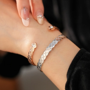 Détail de bracelets manchettes matelassés en argent et or rose avec zircons sur le poignet