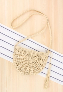 Detail of handmade semi-circle straw crossbody bag with hollow weave and fringe tassel