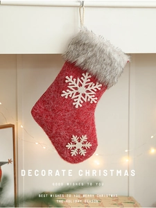 Close-up of a red felt Christmas stocking with white snowflakes and grey faux fur trim