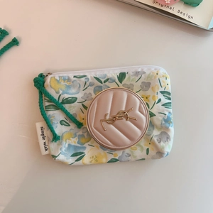 Detail of floral canvas coin purse with zipper and elegant designer cosmetic compact
