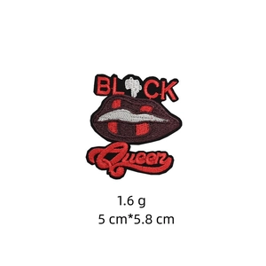 Detail of embroidered patch featuring red lips and Black Queen text design