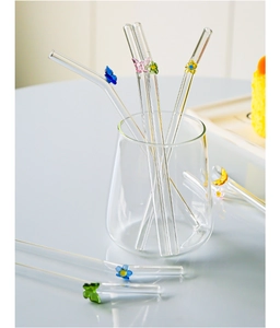 Close-up of heat-resistant glass straws with colorful butterfly and floral decorations
