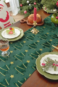 Green plush Christmas runner with gold embroidery on wooden table with festive decor
