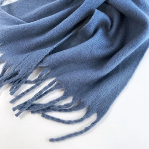 Close-up of blue mohair scarf showing soft brushed texture and fringe detail