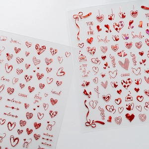 Close-up of red laser heart nail stickers with metal texture and romantic lettering