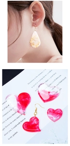 Detailed view of handmade resin droplet earrings and marble-patterned heart pendants