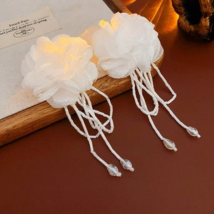 Detail of fabric camellia flower earrings with beaded tassels and drop pendants