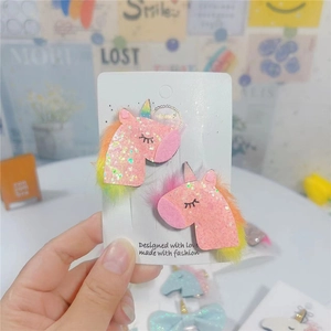 Detail of pink glitter unicorn hair clips with mesh stars on a white display card