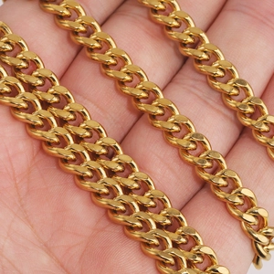 Polished gold stainless steel Cuban curb chain necklace displayed on a hand for scale