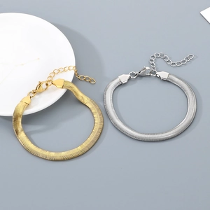 Detail of gold and silver stainless steel flat snake chain bracelets with lobster clasp