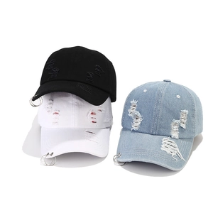 Detailansicht von Jeans-Baseballkappen mit Rissen und Metallringen am Schirm in drei Farben