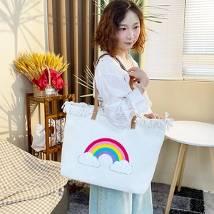Detail of the colorful rainbow sequin embroidery and white fringe on the canvas tote bag