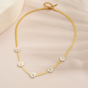 Gros plan du collier chaîne serpent dorée avec cinq breloques fleurs marguerites blanches