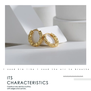 Detail of gold-plated brass hoop earrings with unique hammered irregular texture