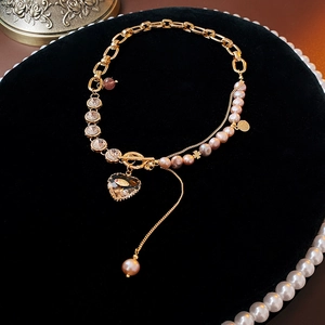 Detail of pink freshwater pearl bracelet with heart pendant on black velvet display