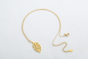 Detailed close-up of a gold leaf pendant necklace with fine chain and lobster clasp