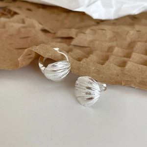 Elegant 925 sterling silver shell earrings with dot texture on a neutral background