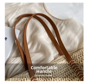 Detail showing the brown leather handles and zipper closure on the beige straw tote bag