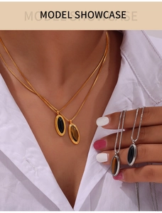 Detail of vintage French style tiger eye stone and black shell pendant on titanium necklace