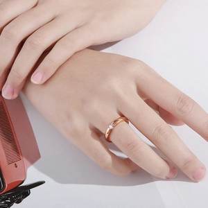 Detail of rose gold stainless steel ring with a single zircon worn on a hand